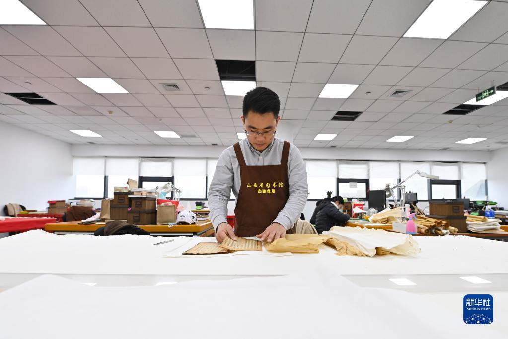 山西省図書(shū)館古書(shū)修復(fù)センターで古書(shū)に當(dāng)て紙を施す程文濤さん（4月21日撮影?楊晨光）。