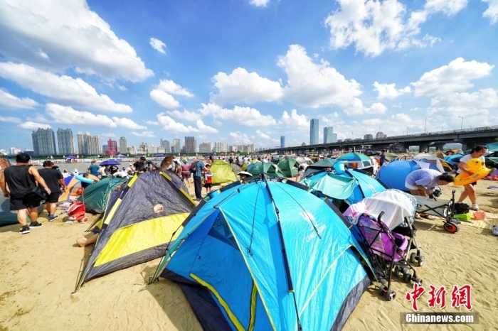 資料寫真：哈爾浜（ハルビン）市の松花江のほとりの海水浴場(chǎng)では、市民が砂浜にテントを張っていた。（撮影?孫漢侖）