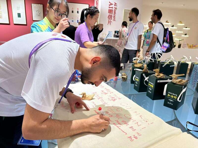 「応援ダック」を受け取って、お禮のメッセージを書(shū)く外國(guó)人選手（寫(xiě)真提供?阿里巴巴）。