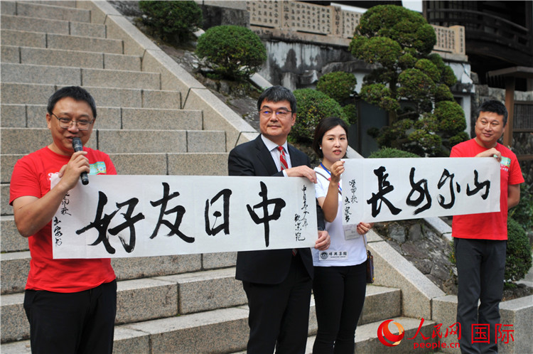 今回のイベントのために書き上げた「中日友好、山高水長」という書道作品を披露する中國文化センターの羅玉泉センター長（撮影?蔣暁辰）。