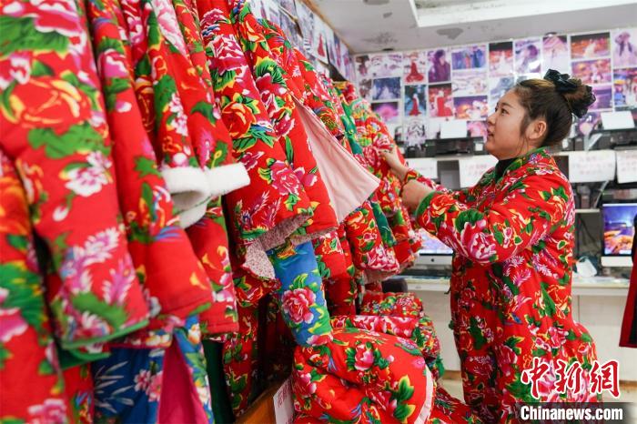 観光客に東北エリアならではの鮮やかな色合いの花柄の綿入れをレンタルするショップ（撮影?趙宇航）。