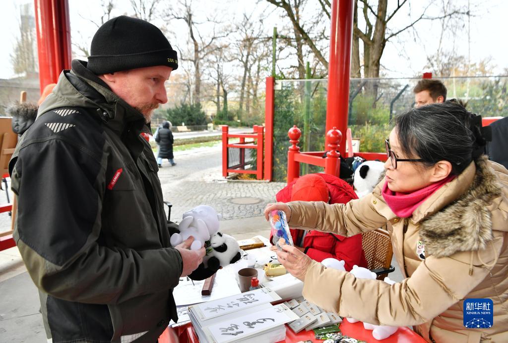 獨ベルリン動物園で、パンダの形をした記念品を飼育員に手渡す、ベルリン中國文化センターの職員（寫真右）（12月8日撮影?任鵬飛）