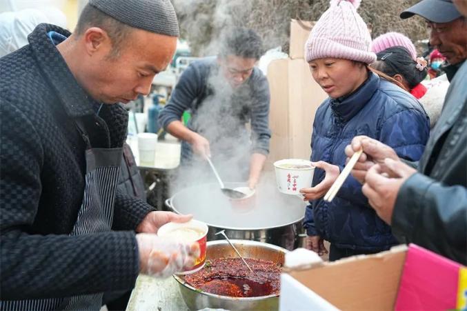 避難所の炊きだしでラーメンを提供する男性たち（撮影?賀勇）。