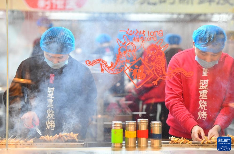 湖南省長(zhǎng)沙市天心區(qū)裕南街街道にある東瓜山夜市美食一條街で、串焼きを作る店員（2月4日撮影?陳澤國(guó)）。