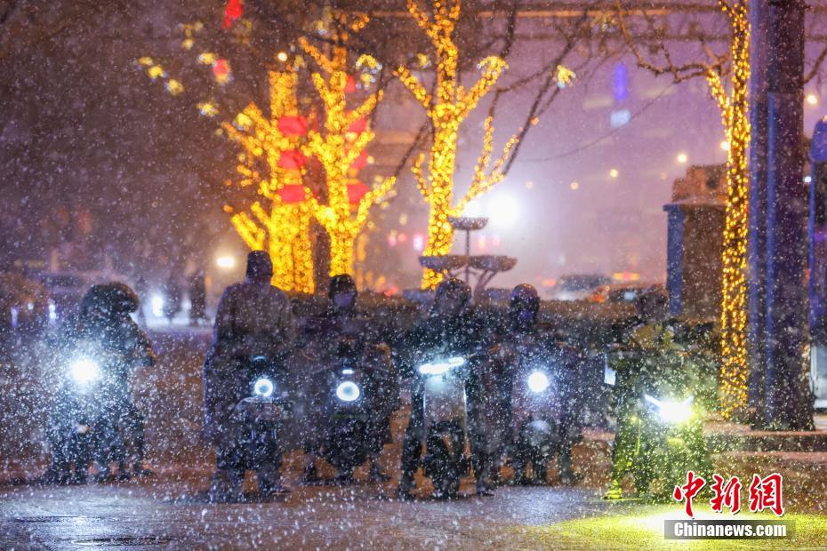 雪の中をバイクで出かける北京市民（2月20日撮影?賈天勇）。