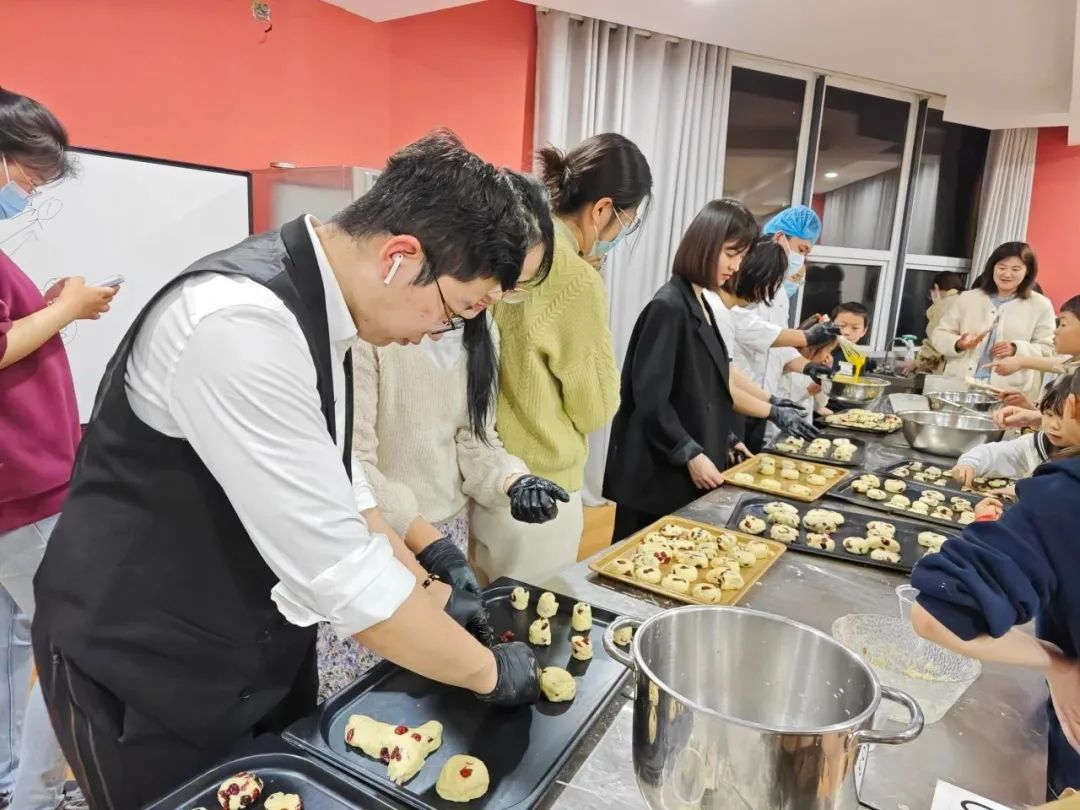 江蘇省徐州新沂市の焼き菓子教室で、先生に教わりながらクランベリースコーンを焼く受講生たち。