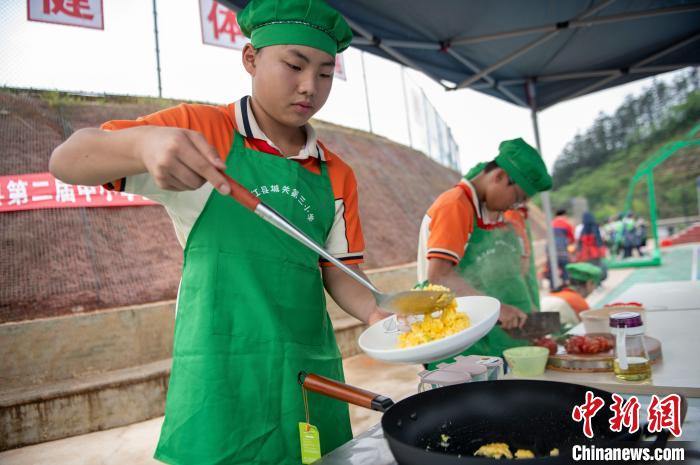 貴州省黔東南苗族?侗族自治州従江県にある城関第三小學(xué)校で、協(xié)力してトマトと卵の炒め物を作る児童たち（5月9日撮影?呉徳軍）。