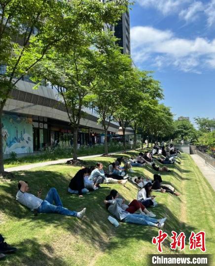 正午に上海市徐匯區(qū)の地下鉄?雲(yún)錦路駅付近の芝生の上で寢転ぶ若者たち（寫真提供?取材対応者）。