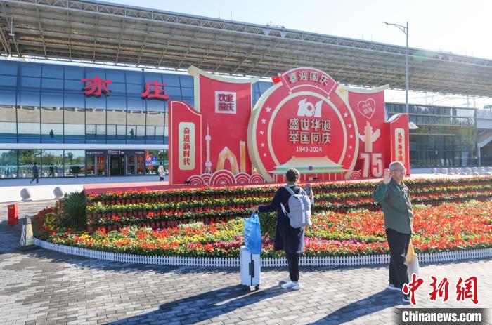 亦荘駅で寫真を撮る旅客（撮影?賈天勇）