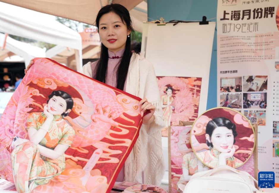 上海市青浦大淀湖の芝生エリアで開かれた展示イベントで、無形文化遺産の文化クリエイティブグッズを見せる上海の無形文化遺産年畫「月份牌」の継承者?姜修宜さん（10月19日撮影?劉穎）。