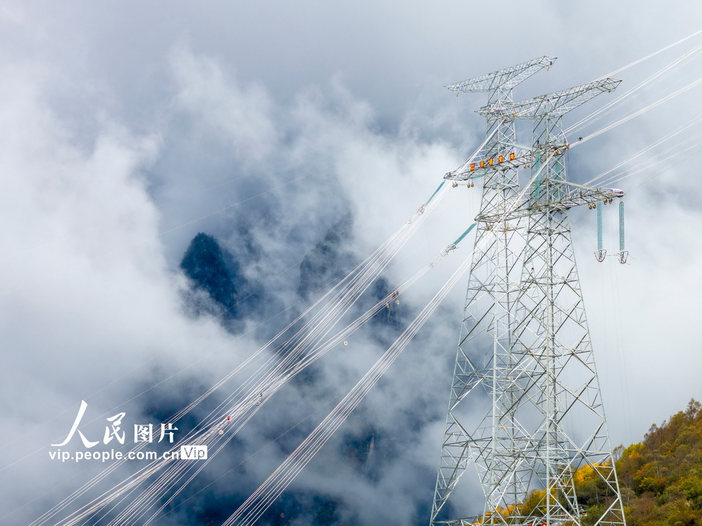 地上800メートル以上の高所でスペーサの取り付け作業(yè)を行う電力會(huì)社の作業(yè)員（10月19日撮影?田海/寫真著作権は人民図片が所有のため転載禁止）。