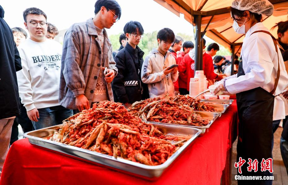 料理を試食する列に並ぶ學(xué)生たち（撮影?張暢）。