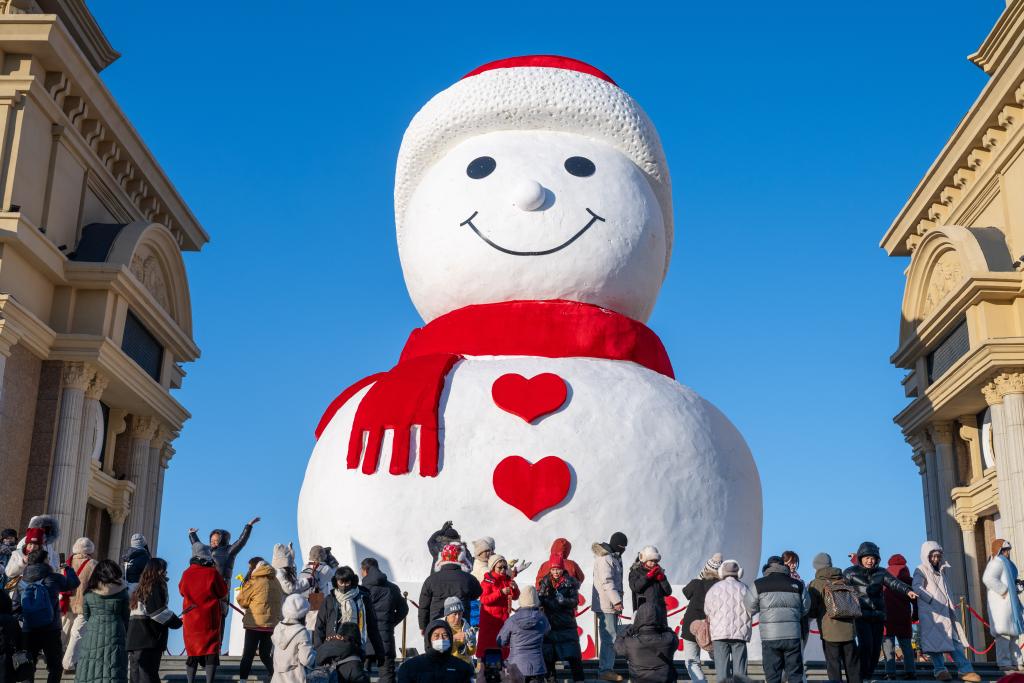 巨大雪だるまをバックにたくさんの見物客が記念撮影を撮る様子（2024年12月17日、撮影?張濤）。