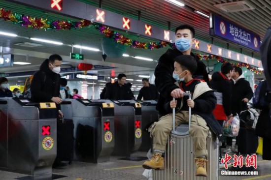 北京西駅でマスクを著用して改札口付近を移動する男性たち（資料寫真、撮影?韓海丹）。