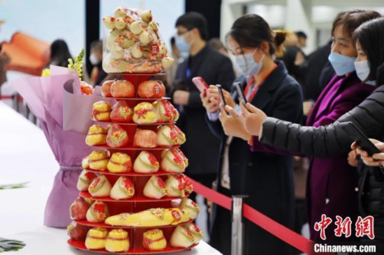 華やかな「面點」の作品をスマホで撮影する女性（撮影?陳陽）。